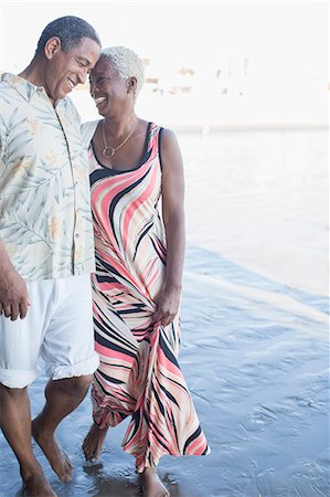 Senior couple walking barefoot on beach Foto de stock - Sin royalties Premium, Código: 6113-07589476