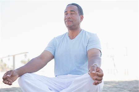 Serene senior man meditating in lotus position on beach Foto de stock - Sin royalties Premium, Código: 6113-07589492