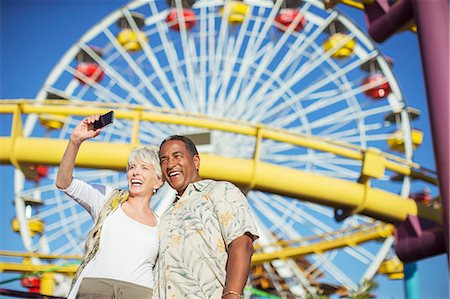 Enthusiastic senior couple taking selfie at amusement park Stock Photo - Premium Royalty-Free, Code: 6113-07589496