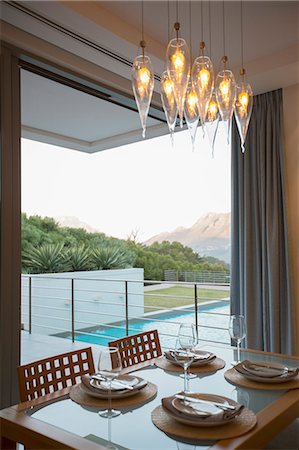 Luxury dining room overlooking balcony and swimming pool Photographie de stock - Premium Libres de Droits, Code: 6113-07589666