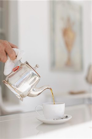 Hand pouring tea from silver teapot Stock Photo - Premium Royalty-Free, Code: 6113-07589606