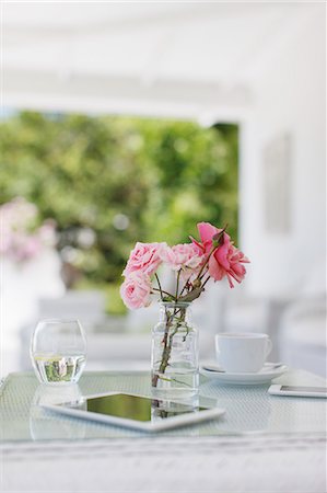 simsearch:6113-07589635,k - Pink roses on patio table next to coffee cup and digital tablet Foto de stock - Sin royalties Premium, Código: 6113-07589613