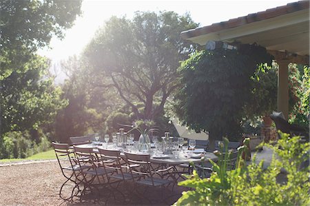 Place settings on sunny rural patio table Stock Photo - Premium Royalty-Free, Code: 6113-07589610