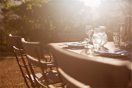 Place settings on sunny tranquil patio table Photographie de stock - Premium Libres de Droits, Code: 6113-07589757