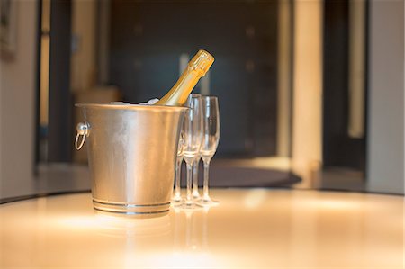 Champagne in silver bucket next to champagne flute Foto de stock - Sin royalties Premium, Código: 6113-07589765