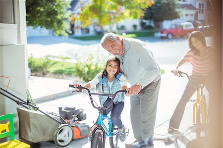 simsearch:6113-07648778,k - Grandfather and granddaughter on bike in garage Photographie de stock - Premium Libres de Droits, Code: 6113-07648774