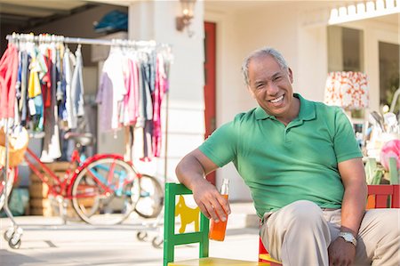 Portrait of smiling man at yard sale Foto de stock - Royalty Free Premium, Número: 6113-07648779