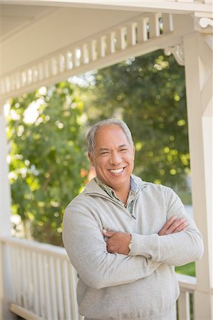 simsearch:6113-07648885,k - Portrait of smiling man on porch Fotografie stock - Premium Royalty-Free, Codice: 6113-07648787