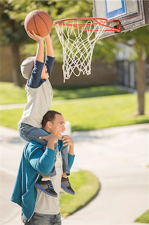 family latino playing - Father and son playing basketball in driveway Stock Photo - Premium Royalty-Free, Code: 6113-07648784