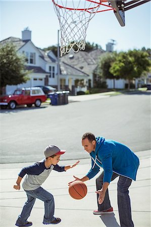 parents play kids - Father and son playing basketball in driveway Stock Photo - Premium Royalty-Free, Code: 6113-07648786