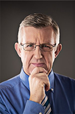 simsearch:6113-07648684,k - Portrait of confident businessman with hand on chin Stock Photo - Premium Royalty-Free, Code: 6113-07648700