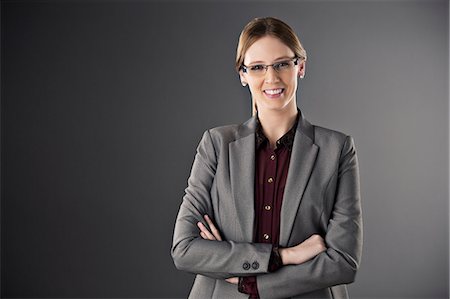 schwarzer hintergrund - Portrait of confident businesswoman with arms crossed Photographie de stock - Premium Libres de Droits, Code: 6113-07648724