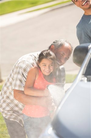 Grandfather and granddaughter washing car in driveway Stock Photo - Premium Royalty-Free, Code: 6113-07648882