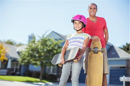 father day copyspace - Portrait of father and daughter with skateboards Stock Photo - Premium Royalty-Free, Code: 6113-07648829