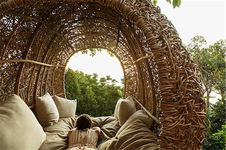 rich people outdoor - Woman laying in nest tree house Stock Photo - Premium Royalty-Free, Code: 6113-07648903