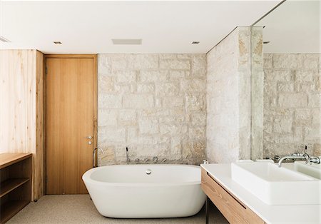 domestic bathroom - Stone walls behind soaking tub in modern bathroom Foto de stock - Sin royalties Premium, Código: 6113-07648925