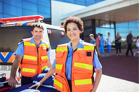 Paramedics smiling by ambulance in hospital parking lot Fotografie stock - Premium Royalty-Free, Codice: 6113-07761947