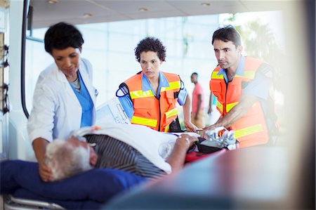 Paramedics and nurse examining patient in ambulance Fotografie stock - Premium Royalty-Free, Codice: 6113-07761955