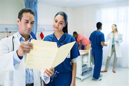 simsearch:6113-07648738,k - Doctor and nurse reading medical chart in hospital room Stock Photo - Premium Royalty-Free, Code: 6113-07761960