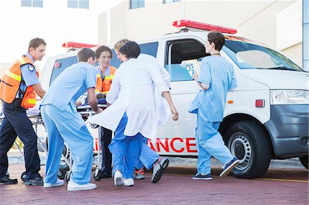 Doctors, nurses, and paramedic examining patient on stretcher Stock Photo - Premium Royalty-Free, Code: 6113-07761968