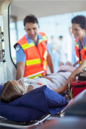 Paramedics examining patient on ambulance stretcher Fotografie stock - Premium Royalty-Free, Codice: 6113-07761973