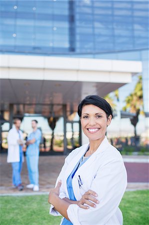 simsearch:649-08084778,k - Doctor smiling outside hospital Fotografie stock - Premium Royalty-Free, Codice: 6113-07761975