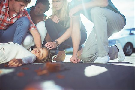 Friends examining injured girl on sidewalk Photographie de stock - Premium Libres de Droits, Code: 6113-07761928