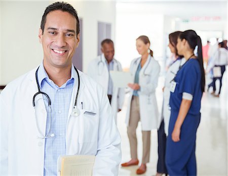 simsearch:6113-07762059,k - Doctor smiling in hospital hallway Stock Photo - Premium Royalty-Free, Code: 6113-07762072