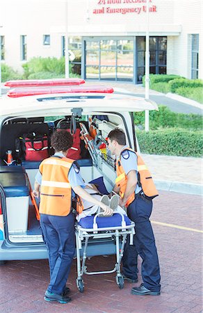 Paramedics wheeling patient out of ambulance Stock Photo - Premium Royalty-Free, Code: 6113-07762092