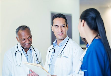 Doctors and nurse talking in hospital hallway Photographie de stock - Premium Libres de Droits, Code: 6113-07762005