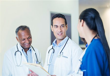 simsearch:6113-07762035,k - Doctors and nurse talking in hospital hallway Stock Photo - Premium Royalty-Free, Code: 6113-07762005