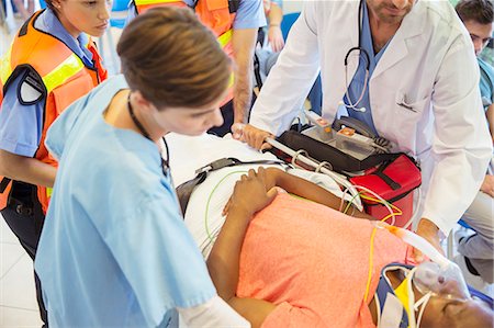 simsearch:649-07119232,k - Doctor, nurse and paramedics examining patient on stretcher Stock Photo - Premium Royalty-Free, Code: 6113-07762013