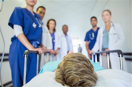 simsearch:6113-07589273,k - Doctors and nurses wheeling patient in hospital hallway Stock Photo - Premium Royalty-Free, Code: 6113-07762023