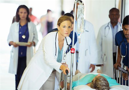 Doctors and nurses wheeling patient in hospital hallway Photographie de stock - Premium Libres de Droits, Code: 6113-07762024