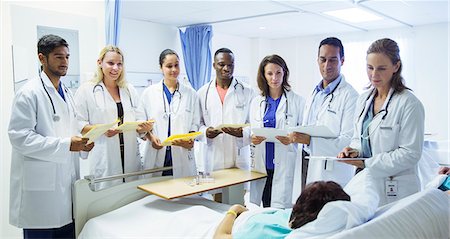 simsearch:6113-07905839,k - Doctor and residents examining patient in hospital room Stock Photo - Premium Royalty-Free, Code: 6113-07762037
