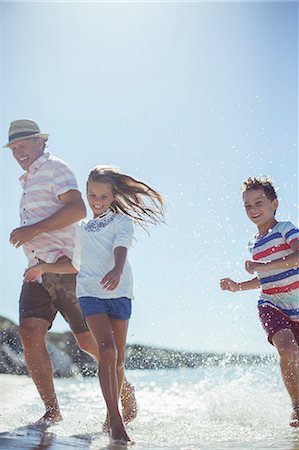 simsearch:6113-07731285,k - Family running in water on beach Stock Photo - Premium Royalty-Free, Code: 6113-07762148