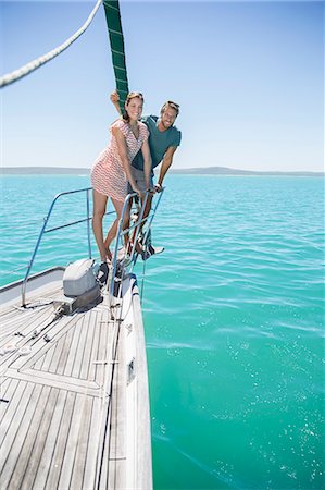 sailboat couple - Couple standing on front of sailboat Stock Photo - Premium Royalty-Free, Code: 6113-07762170