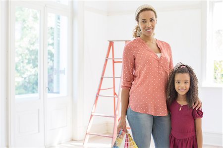 poser (devant un appareil photo) - Mother and daughter smiling in living space Photographie de stock - Premium Libres de Droits, Code: 6113-07762249