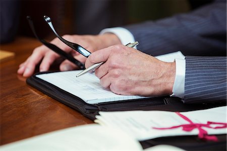 eyeglasses - Close up of lawyers hands in courtroom Stock Photo - Premium Royalty-Free, Code: 6113-07762347