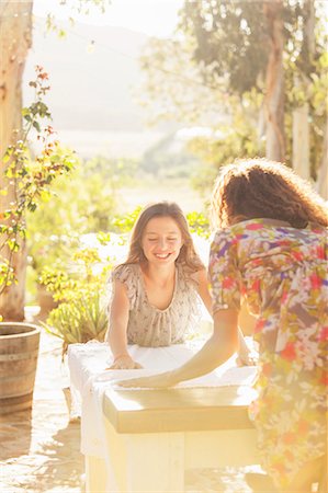 Mother and daughter laying table cloth on table Photographie de stock - Premium Libres de Droits, Code: 6113-07762574