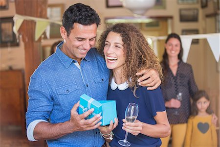 family gathering laughing - Couple opening gift together Stock Photo - Premium Royalty-Free, Code: 6113-07762597