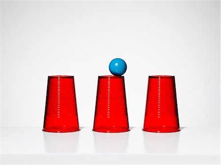 Blue ball balancing on middle of three red cups Stockbilder - Premium RF Lizenzfrei, Bildnummer: 6113-07790182