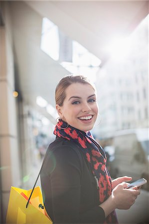 Woman using cell phone on city street Stock Photo - Premium Royalty-Free, Code: 6113-07790243