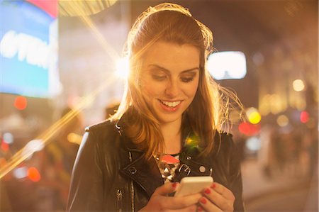 smartphone city night - Woman using cell phone on city street at night Stock Photo - Premium Royalty-Free, Code: 6113-07790252