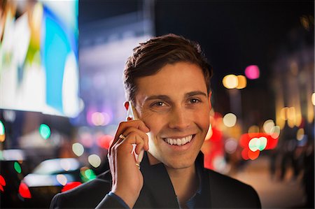 smartphone city night - Man talking on cell phone on city street at night Stock Photo - Premium Royalty-Free, Code: 6113-07790259
