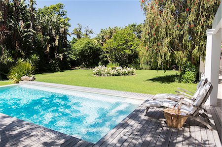 simsearch:600-03615788,k - Lawn chairs overlooking backyard and swimming pool Photographie de stock - Premium Libres de Droits, Code: 6113-07790492