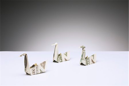 Origami swans made of dollar bills on counter Fotografie stock - Premium Royalty-Free, Codice: 6113-07790406