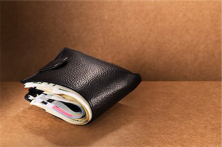 portefeuille - Close up of full wallet on counter Photographie de stock - Premium Libres de Droits, Code: 6113-07790429