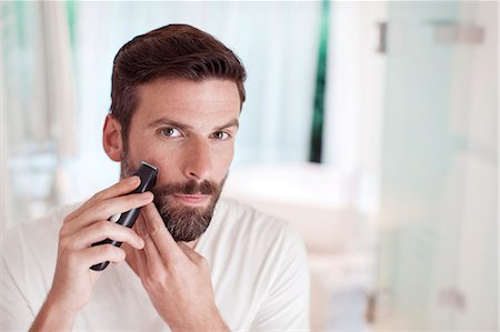 Man trimming beard in bathroom mirror Photographie de stock - Premium Libres de Droits, Code: 6113-07790549