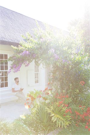 simsearch:6113-07790487,k - Man on porch admiring flowers in backyard Foto de stock - Royalty Free Premium, Número: 6113-07790573